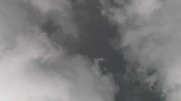 Le ciel est couvert de nuages gris en prévision de la pluie. Les nuages bougent vite. Entre les nuages gris, un espace est visible avec des nuages sombres 