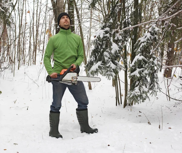 Mann in Stiefeln und Kettensäge im Wald — Stockfoto