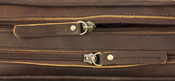 pair of zippers on the brown leather bag, top view