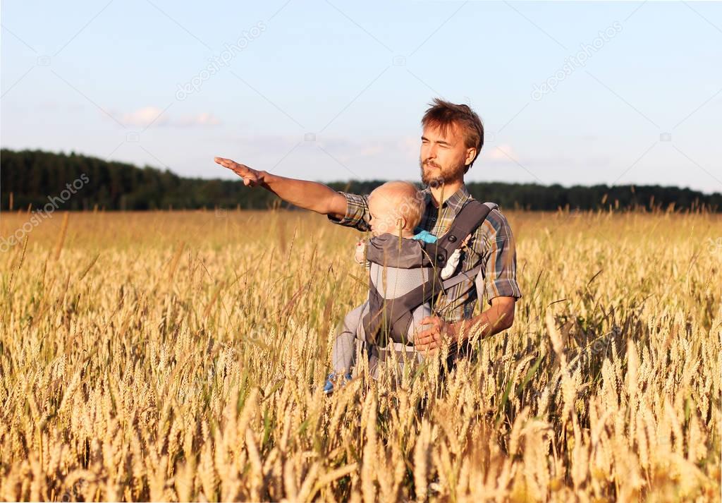 father shows his son a field of barley