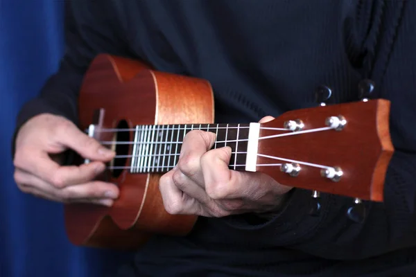 Hudebník hraje na ukulele, malá hloubka ostrosti — Stock fotografie