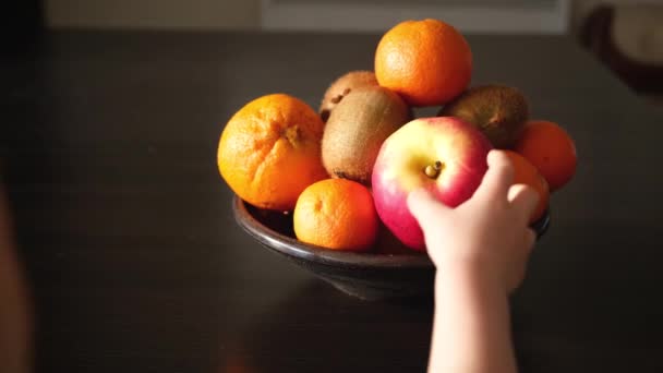 小さな子供の手は 果物の完全なプレートから新鮮なリンゴを取ります 朝食のためのベジタリアンやビーガン子供の健康的な食べ物の軽食 一人称視点のPov — ストック動画