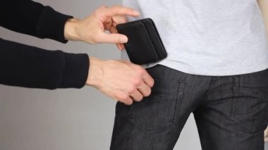 Eller siyah deri çantaya birinin pantolonunun arka cebine, yankesici hırsızlığının pişmanlığı ya da sigorta şirketinin tazminatı, çalınan cüzdanın iadesi, yakın plan.
