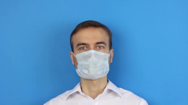 正面以人为中心 摘除口罩 完成病毒传播或污染检疫 蓝色背景 — 图库视频影像