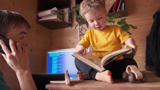 Père Travaille Maison Sur Ordinateur Parle Sur Smartphone Petit Enfant — Video