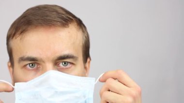 Erkek kafasına ön görüş, tıbbi maske takın, virüs koronavirüsünün önlenmesi veya korunması veya kirliliği, doktor ya da hasta dikkatlice bakın, gri arkaplan ve başlıklar için kopyalama alanı