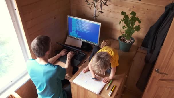 父亲在家里的电脑上工作 小孩坐在旁边画画 在家隔离的观念 自我隔离的家庭坦率的生活方式 为人父母的困难 — 图库视频影像