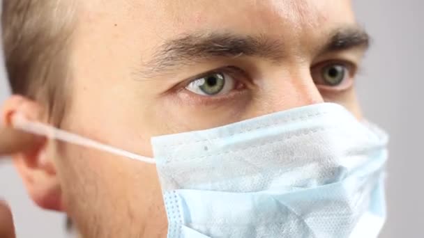近视脸 戴口罩的男人 预防或保护病毒感染或污染 严肃的医生或科学家凝视 灰蒙蒙的背景 — 图库视频影像