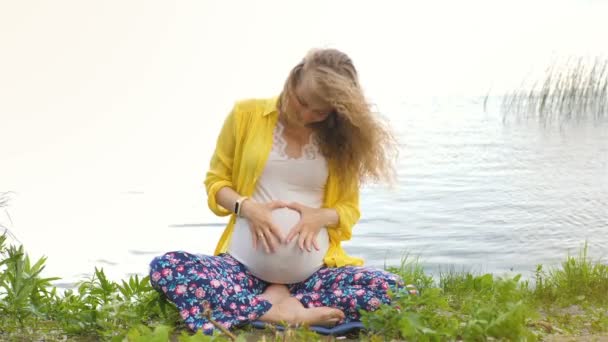 Gravid yoga prenatal moderskap gör olika övningar. i parken på gräset, andning, stretching, Statik. Utomhus, skog och floden. begreppet hälsosam livsstil och avkoppling. Meditation. — Stockvideo