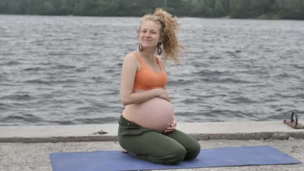 Gezonde zwangere vrouw doen yoga in natuur in openlucht — Stockvideo