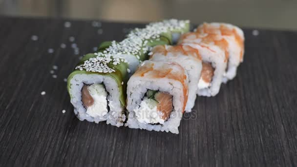 Le gros plan des baguettes contient des sushis maki gunkan rouler sur une assiette ou un plateau ensemble. Servi dans un bar-restaurant japonais. Vue de dessus, plan plat. Contexte alimentaire. espace de copie . — Video