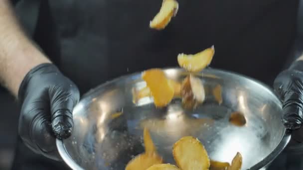 Gebakken aardappel gemengd met zout. Gefrituurde chips vallen, fast food, junk food — Stockvideo