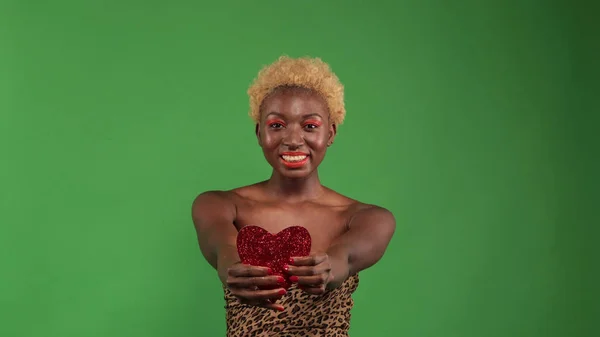 Feliz mulher afro-americana romântica segurando um símbolo de coração de papel vermelho de amor e conexão no fundo azul. Dia dos Namorados — Fotografia de Stock