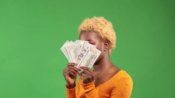 Afrikansk amerikansk kvinna med en bunt dollar håller en fläkt i händerna täcker hennes ansikte — Stockfoto