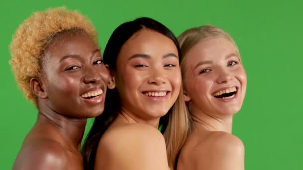 Tři mladé dívky jsou Afroameričanky, Asiatky a Evropanky s holými rameny, stojící v polosaku a usmívající se do kamery, konceptu zdravého těla a nezávislých žen — Stock video