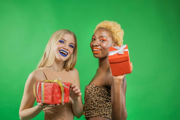 Mode livsstil porträtt av två flickvänner som håller ljusa födelsedagspresenter gåvor.Bli galen, och göra roliga ansikten — Stockfoto