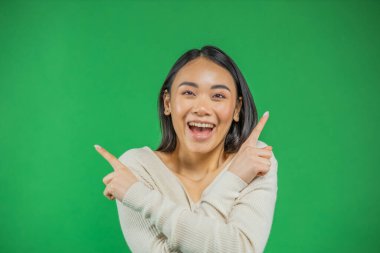 Güzel Asyalı genç bir kadın yeşili işaret ediyor..