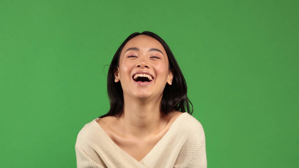 Beautiful young cheerful funny Asian girl happily smiles into the camera portrait with a natural skin tone with minimal amount of makeup on her face. A concept of a positive mood, a mood for joy, fun