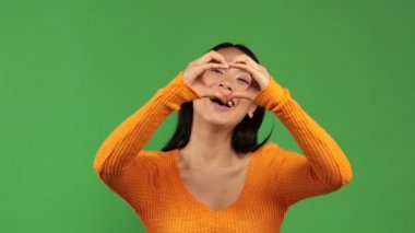 Ellerini kullanan genç Asyalı kadın gülümseyerek ellerini kendine doğru uzatıyor. Mutluluk kavramı.