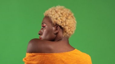 Çıplak omuzlu genç Afro-Amerikalı kadın, izole bir geçmişe sırtını dönüyor, güzellik ve gençlik kavramına.