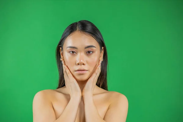 Serious joven asiático mujer en un luz verde fondo — Foto de Stock