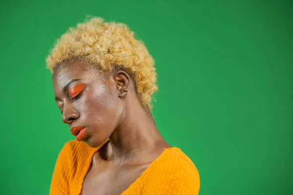 Mörkhyad kvinna med kort ljus frisyr i orange blus — Stockfoto