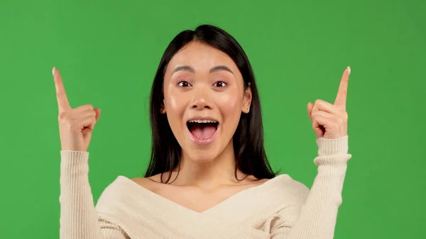 Beautiful Asian woman wearing white blouse over isolated background sign of success making positive hand gesture, pointing fingers smile and happy. Looking at the camera with a cheerful expression — Stock Photo, Image