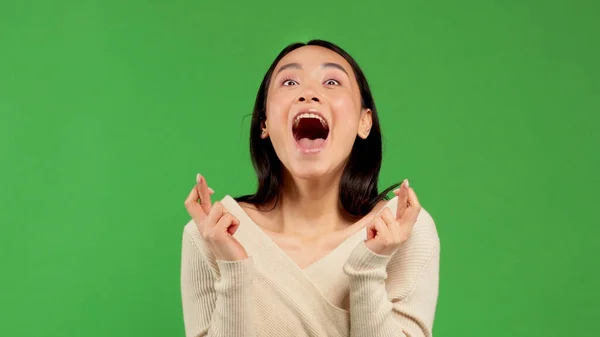 Menina expressa suas emoções alegres com os dedos cruzados, menina asiática mostra suas emoções positivas — Fotografia de Stock