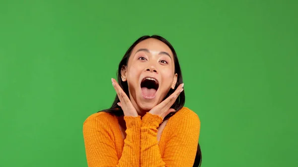 Cheerful cry of young asian woman in bright blouse holds her hands near face without touching face — Stock Photo, Image