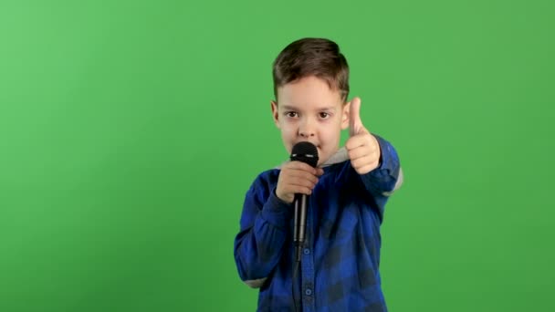 Lindo niño cantando canción mientras sostiene el micrófono y muestra el pulgar sonriendo a la cámara, karaoke divertido entretenimiento para niños — Vídeos de Stock