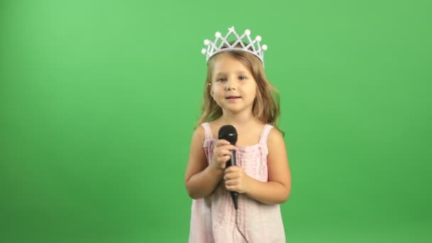 Komik, sevimli, mutlu küçük kız mikrofona şarkı söylüyor, sevimli küçük Amerikan ya da Avrupalı bebek müzik eşliğinde eğleniyor, sadece şarkıcı gibi davranarak eğleniyor. — Stok video