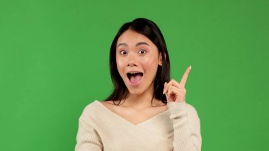 Yurika adında bir kadın. Sıradan, güzel, genç, melez Çinli, beyaz iş kadını yeşil arka planda izole edilmiş.