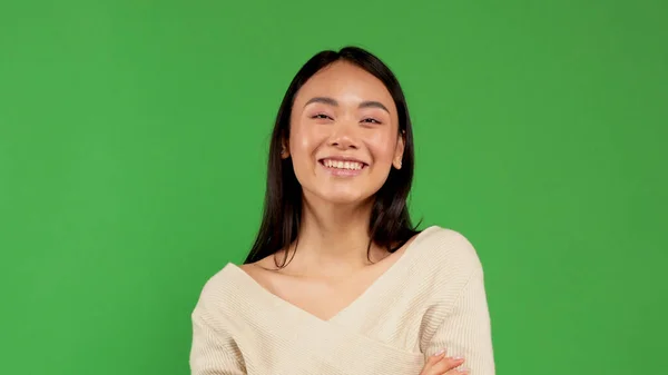 Азиатка изолирована на белом фоне. Женщина со смешанной расой улыбается и выглядит счастливой в легкой футболке. — стоковое фото