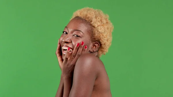Retrato de uma jovem afro-americana muito sorridente segurando seu rosto em suas mãos e sorrindo surpreso. Conceito de beleza feminina — Fotografia de Stock