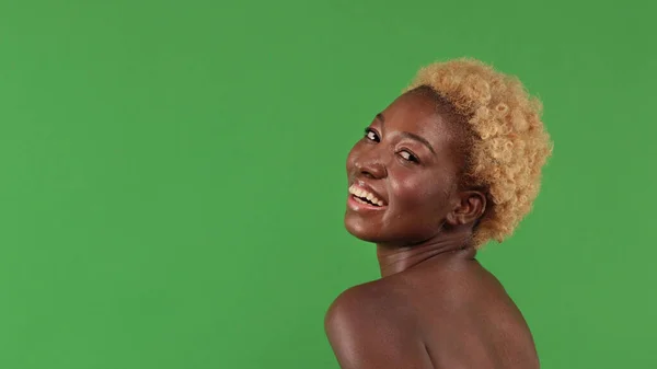 Porträtt av vacker mörkhyad kvinna med kort hår, afro-amerikan hundra med naken rygg vänder och tittar leende mot kameran — Stockfoto