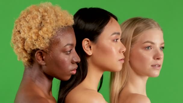 Trois jeunes femmes de races différentes, aux épaules dressées de profil et regardant d'un côté. Fond vert isolé. Modèles 4K Pouting , — Video