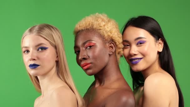 Primer plano de hermosa joven africana asiática y europea mujer mirando a la cámara. Retrato de tres hermosas mujeres de diferente raza sonriendo. Concepto de belleza de África caucásica o asiática y europea — Vídeos de Stock