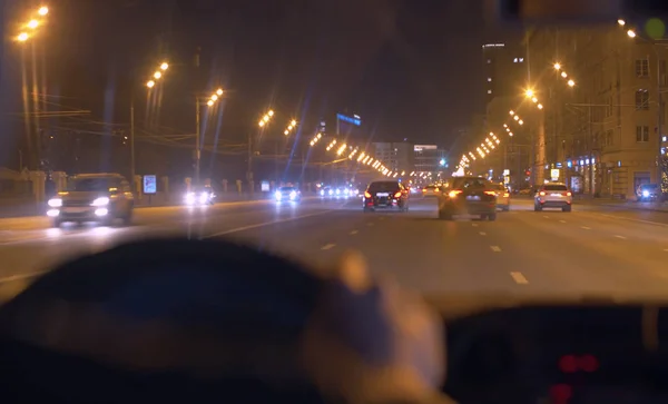 Gece şehir caddesi ön camdan geçiyor.