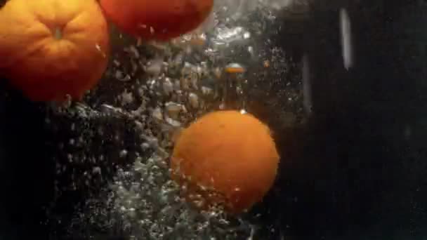 Nahaufnahme Frischer Orangen Die Mit Einem Großen Spritzer Auf Schwarzem — Stockvideo