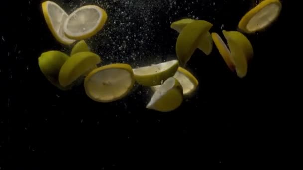 Zavřít Krájené Čerstvé Citrony Padající Vody Černém Pozadí — Stock video