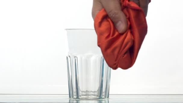 手前に赤い布で手拭きガラスを閉じます 後ろにはグラスがある 白の背景透明性スローモーション — ストック動画