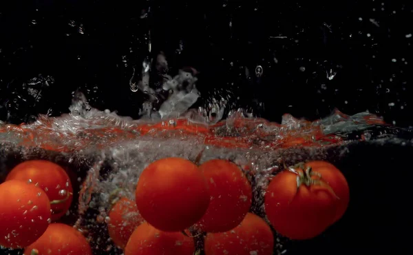 Tomatoes falling into the water — Stock Photo, Image