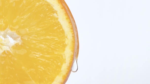 半圆片橙子 特写宏观拍摄一滴果汁流过桔子皮 健康素食的水果 慢动作 白色背景 — 图库视频影像