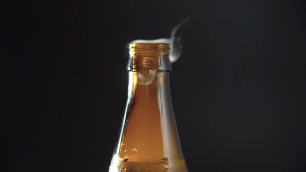 Закройте Человеку Руку Положив Бутылку Пива Стол Открыв Черном Фоне — стоковое видео