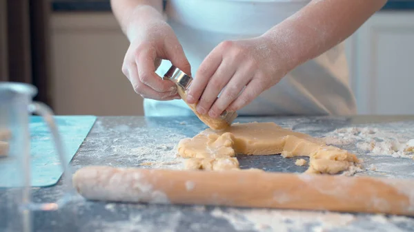 Girl making cookies with a cookie cutter