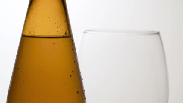 Cierra Botella Cerveza Fría Sobre Mesa Una Copa Vino Detrás — Vídeos de Stock