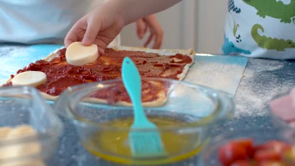 两个做披萨的年轻厨师手拉手 把切碎的奶酪放在面团上的配料 — 图库视频影像