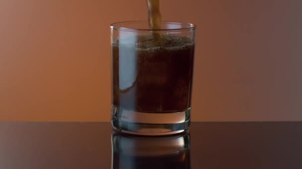Cola vertiendo en un vaso con whisky y hielo — Vídeo de stock