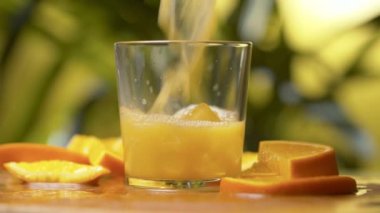 Fresh orange juice flowing into a glass