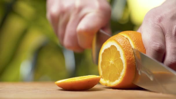 Мужская рука режет апельсин — стоковое видео